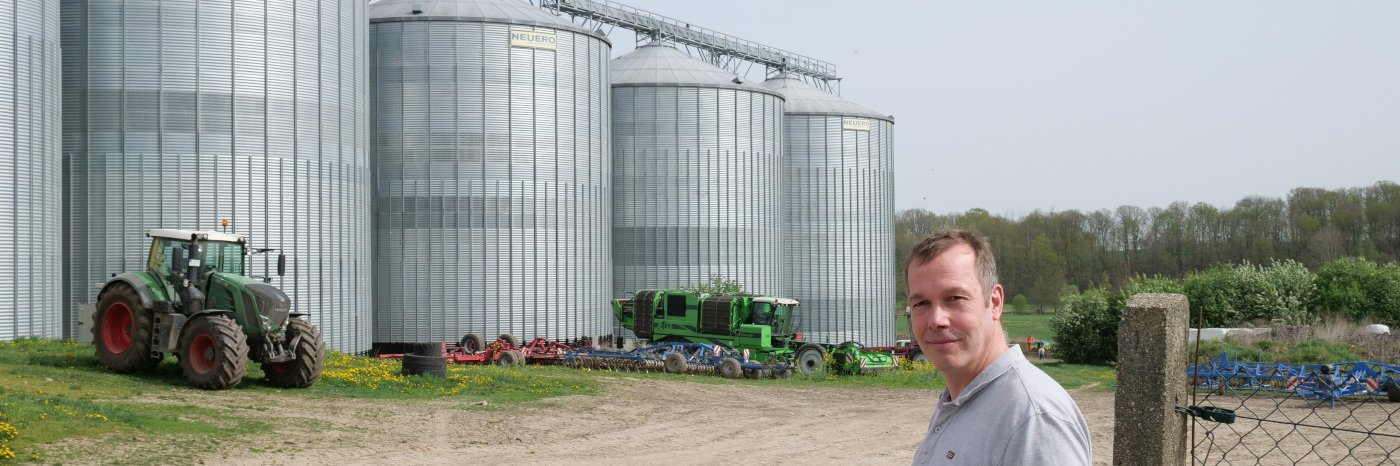 Markus Wiggert steht vor drei großen Getreidesilos
