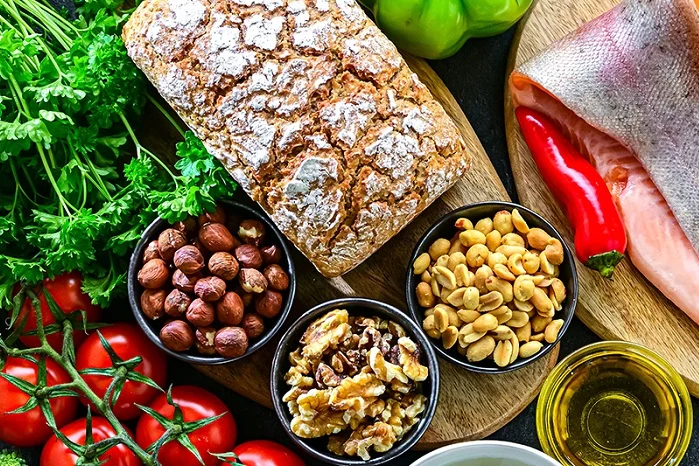 Verschiedene Lebensmittel wie Gemüse, Brot, Fisch, Nüsse und Öle.