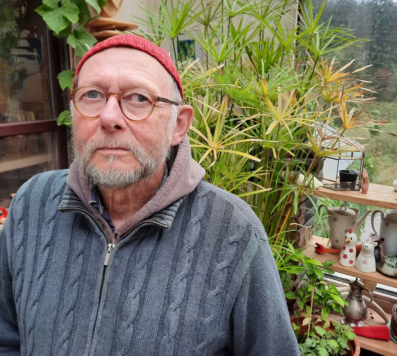 Mann mit Brille und roter Mütze schaut in die Kamera.