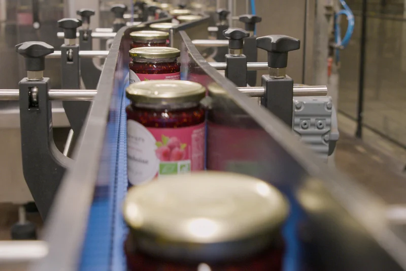 Bio-Marmelade verlässt Fließband nach der Verarbeitung. Klick führt zu Großansicht.