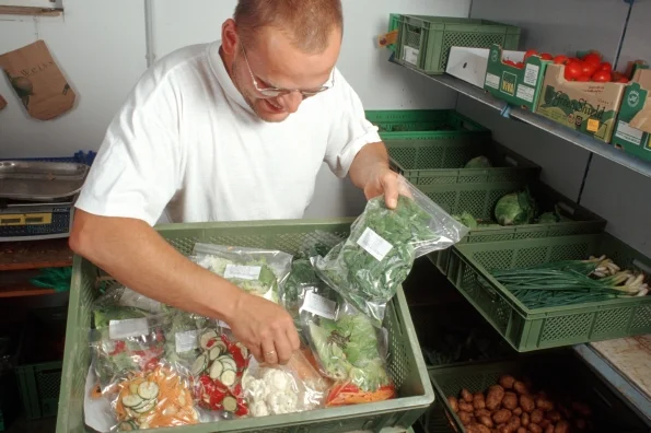 Koch bekommt vakuumverpacktes Gemüse. Klick führt zu Großansicht in neuem Fenster