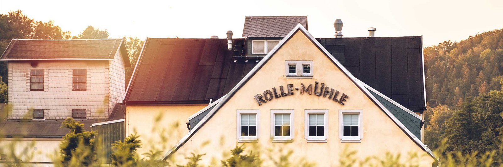Ein Bild von einem Haus mit dem Schriftzug "Rolle Mühle".