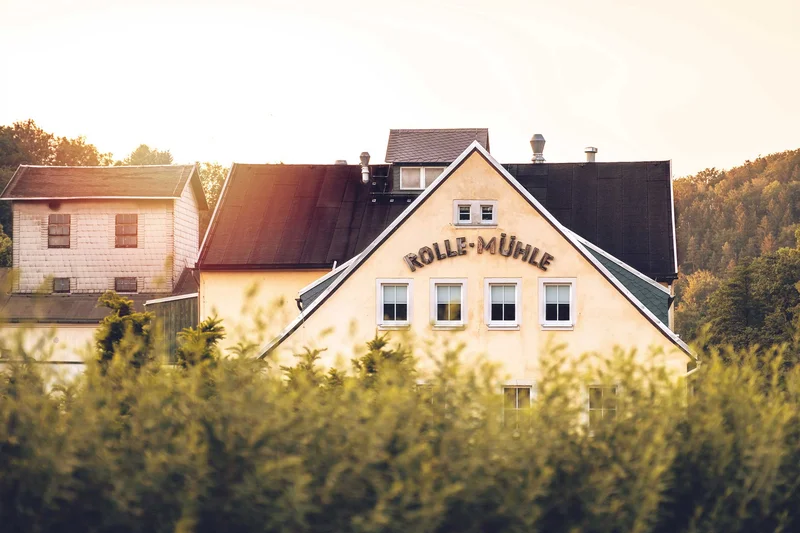 Ein Bild von einem Haus mit dem Schriftzug "Rolle Mühle".