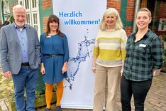 Wiebke Gätjen, Dr. Christina Aue, Alice Woelk und Egon Harms vor OOWV-Plakat