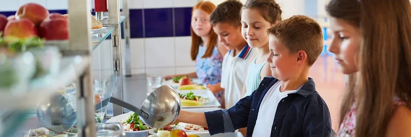 Kinder an einer Essensausgabe einer Schulkantine.