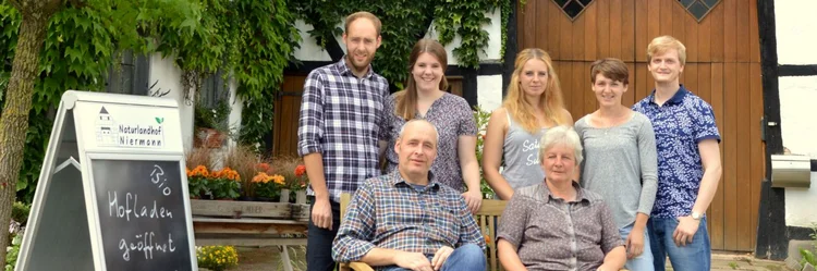 Familie vor einem Fachwerkhaus
