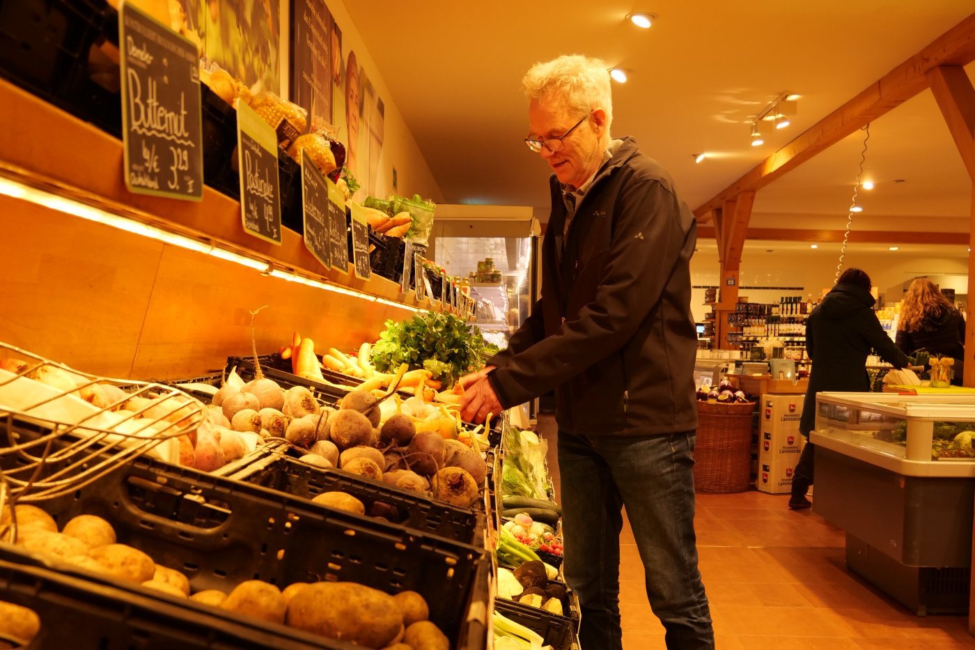 Rolf Winter vor Gemüseregal im Hofladen. (Klick führt zu Großansicht in einer Lightbox. Zum Schließen der Lightbox ESC drücken.) 