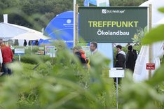 Ein Schild inmitten einer Feldtage-Messezeltlandschaft. Es enthält die Aufschrift "Treffpunkt Ökolandbau". Klick führt zu Großansicht.