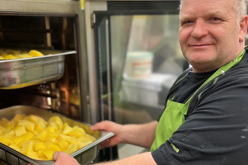 Mann schiebt Kartoffeln in den Ofen
