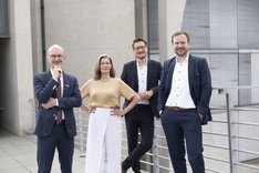Eine Frau und drei Männer blicken freundlich in die Kamera. Klick führt zu Großansicht.