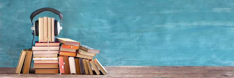 Bücherstapel mit Kopfhörern.