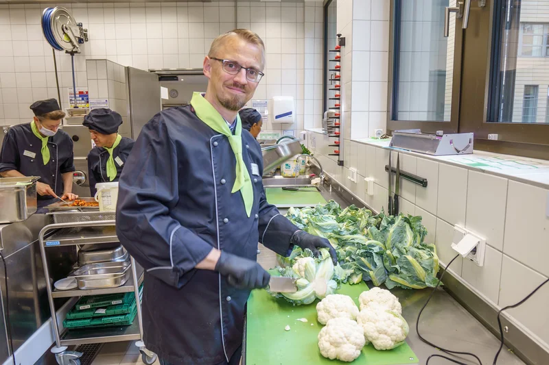 Denis Florschütz schneidet Blumenkohl in der Küche. Klick führt zu Großansicht in einer Lightbox. Zum Schließen der Lightbox ESC drücken.