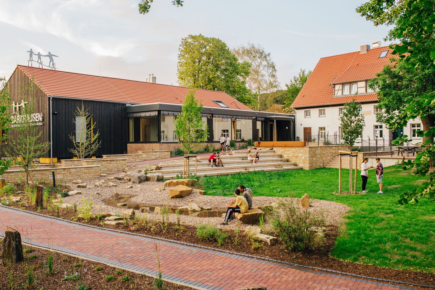 Blick auf das Schullandheim Barkhausen mit Spielgelände im Vordergrund. Kick führt zu Großansicht in neuem Fenster.