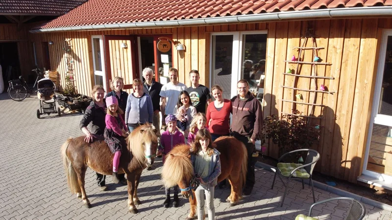Menschengruppe mit zwei Shetlandponys. Klick führt zu Großansicht im neuen Fenster.