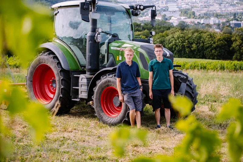 Zwei Männer vor einem Traktor. Klick führt zu Großansicht.