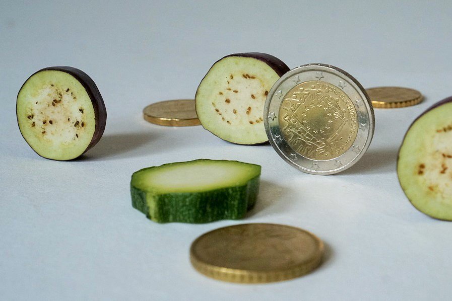 Münzen und Zucchinischeiben auf dem Tisch.