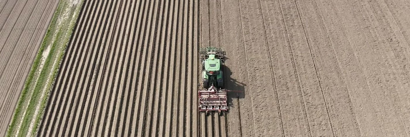 Traktor auf einem Feld, fotografiert von oben.