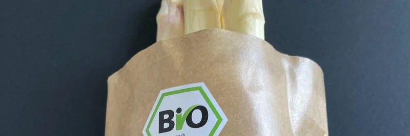 Frischer Bio‑Spargel in papierbasierter Verpackung mit EU‑Bio‑Siegel.
