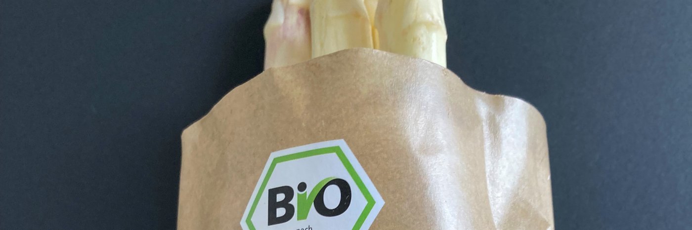 Frischer Bio‑Spargel in papierbasierter Verpackung mit EU‑Bio‑Siegel.