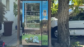 Hofladenautomat unter einem Baum.