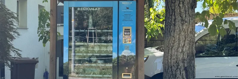 Hofladenautomat unter einem Baum.
