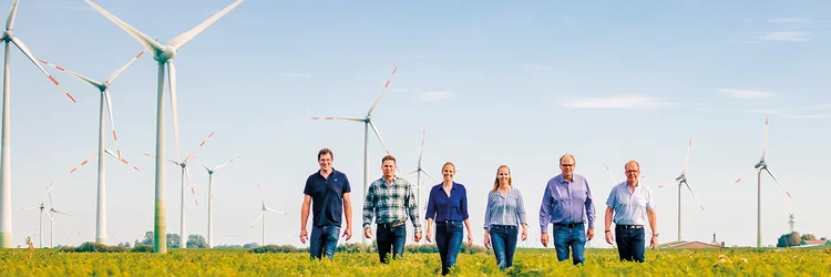 Sechs Personen gehen in einer Reihe über das Feld