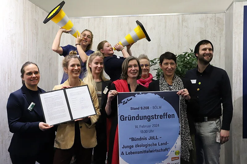 Gruppenfoto von Menschen, die Plakat und Textdokumente in die Kamera halten.