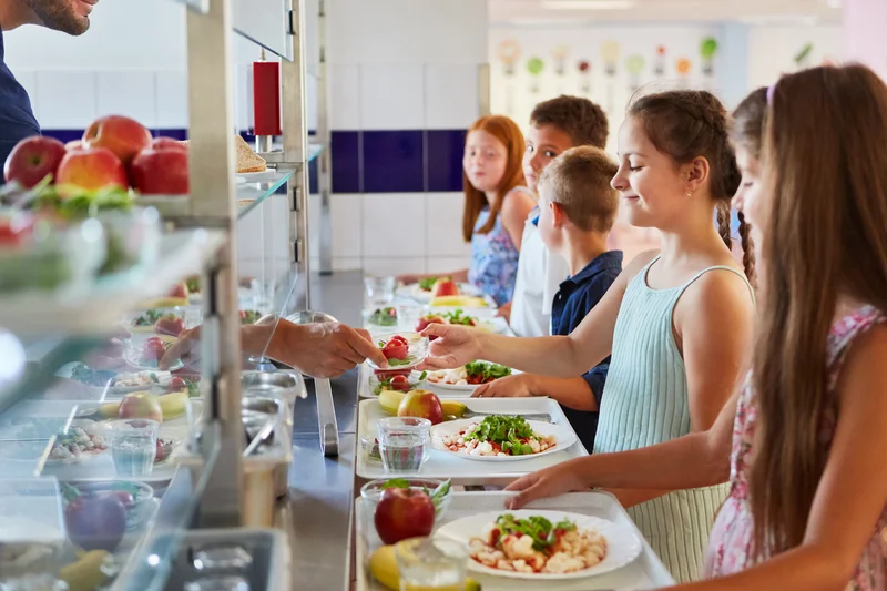 Kinder an der Essensausgabe einer Kantine