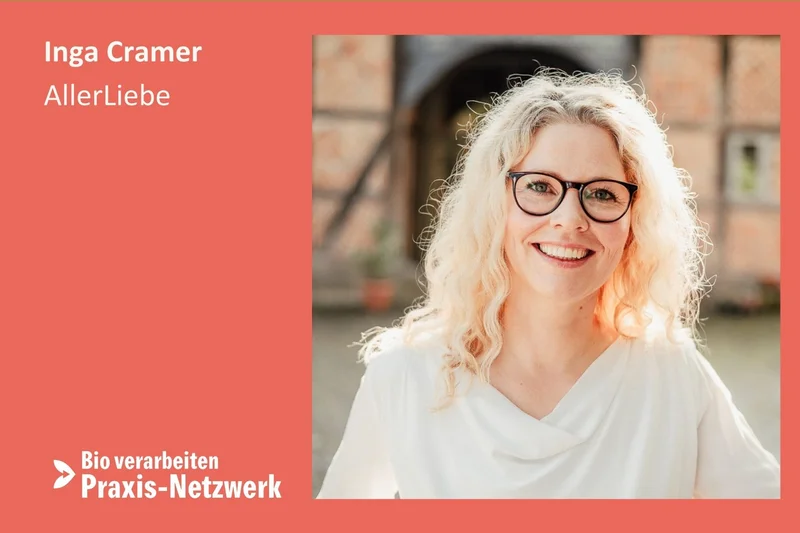 Frau mit Brille lacht in Kamera. Klick führt zu Großansicht.