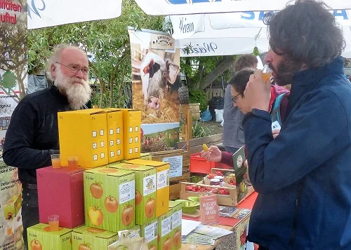 Erzeuger und Kunde am Marktstand. Klick führt zu Großansicht im neuen Fenster.