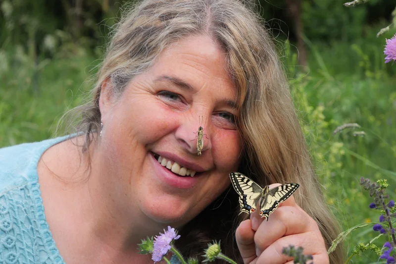 Biodiversitätspädagogin Christiane Denzel mit Schwalbenschwanz. Klick führt zu Großansicht in neuem Fenster.