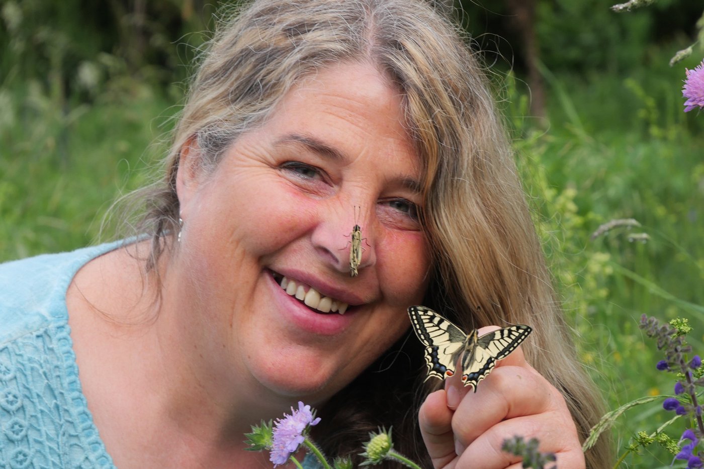 Biodiversitätspädagogin Christiane Denzel mit Schwalbenschwanz. Klick führt zu Großansicht in neuem Fenster.