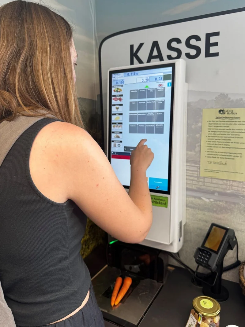 Kundin an der Kasse im SB-Hofladen.