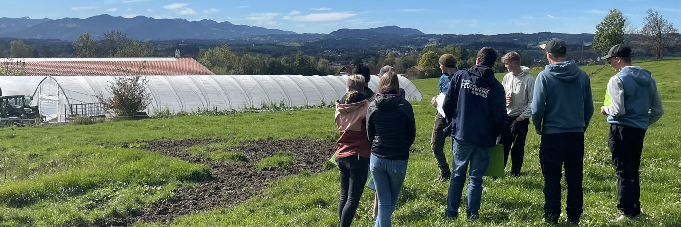 Auszubildende auf dem Feld eines Bio-Hofs.