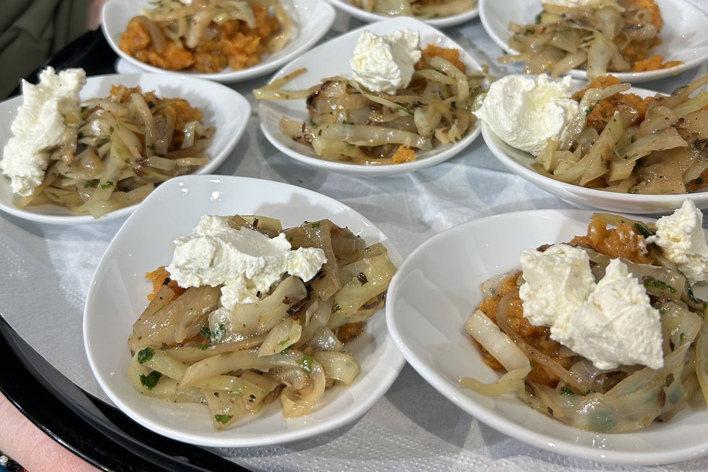 Schmorkohl mit frischer Petersilie und gestampften Süßkartoffeln angerichtet auf kleinen Tellern.