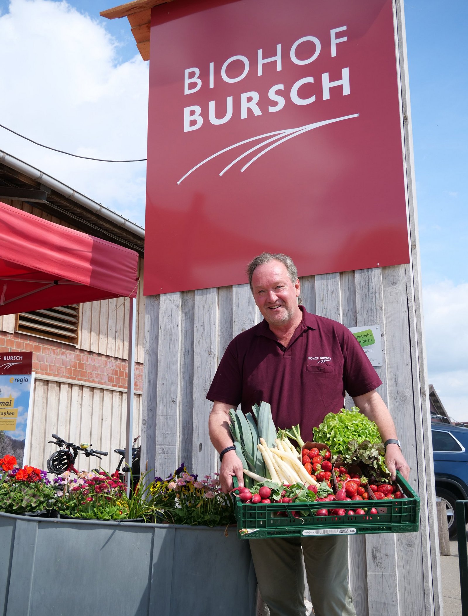 Heinz Bursch steht mit einer Gemüsekiste vor seinem Hofladen.