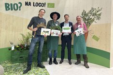 Vier Menschen lachen in die Kamera. Klick führt zu Großansicht.