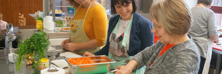 Workshop-Teilnehmerinnen putzen und scheiden Möhren.