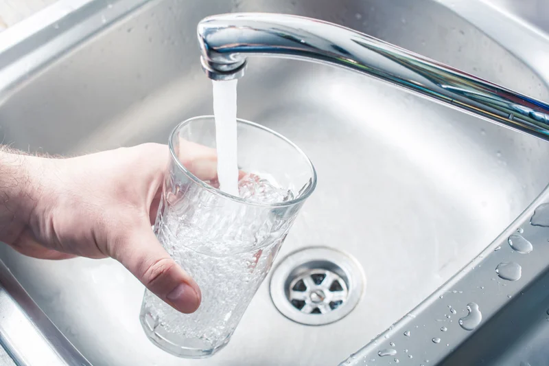 Ein Glas wird unter einem geöffneten Wasserhahn mit klarem Leitungswasser gefüllt. Klick führt zu Großansicht in neuem Fenster, schließen per ESC.