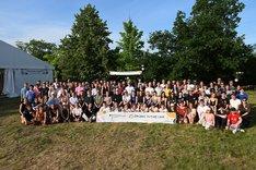 Die Teilnehmenden des Organic Future Camp auf einer Wiese mit dem Banner des Organic Future Camps in der Mitte. Alle lachen in die Kamera. Klick führt zu Großansicht.