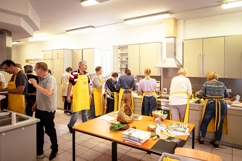 Eine Gruppe von Menschen arbeitet in einer großen Betriebsküche.