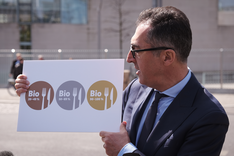 Bundeslandwirtschaftsminister Özdemir hält ein Plakat mit den drei AHV-Siegeln in die Kamera