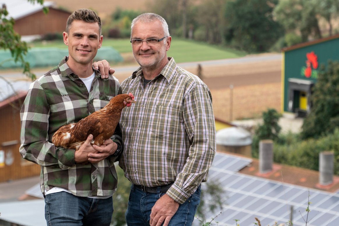 Zwei Landwirte mit Hühnern. Klick führt zu Großansicht im neuen Fenster.