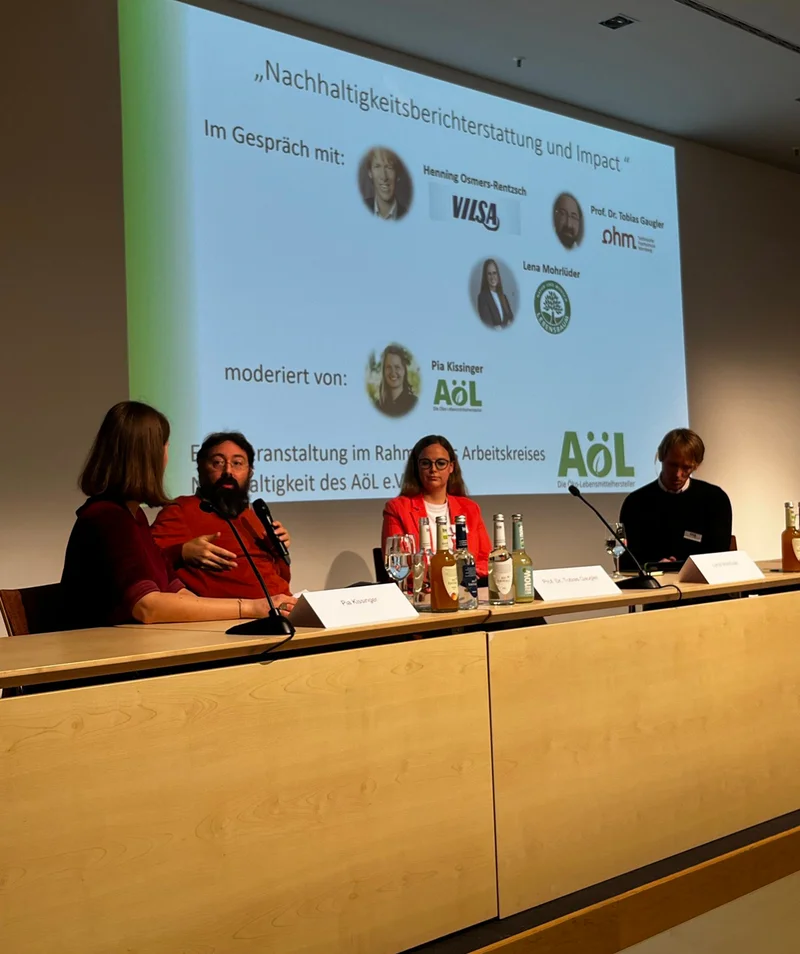 Personen sitzen auf dem Podium einer Biofach-Veranstaltung zum Thema Nachhaltigkeitsberichterstattung. Klick führt zu Großansicht in neuem Fenster.