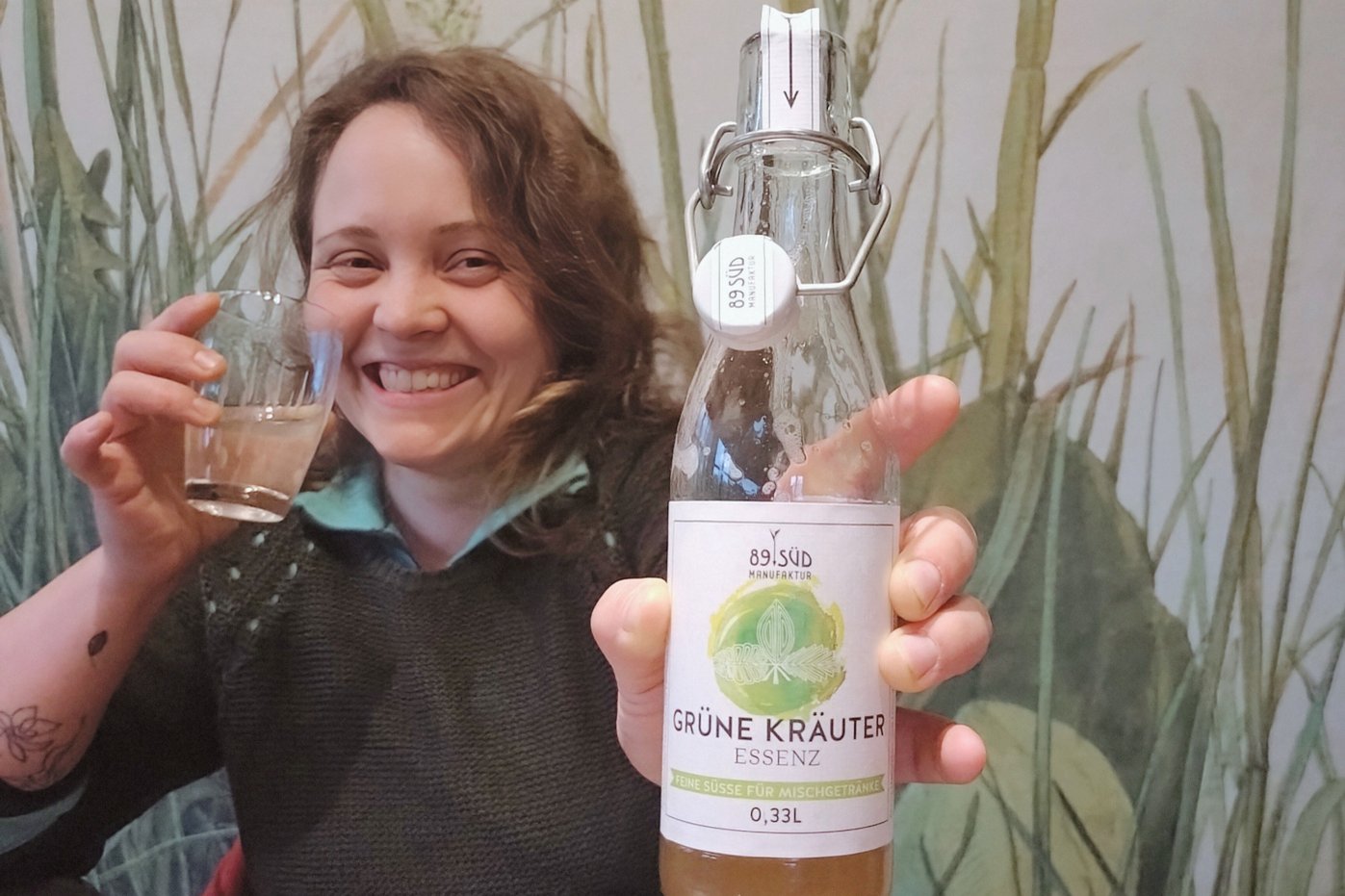Lucia Birkmeir, Ökojunglandwirtin, hält eine Flasche "Grüne Kräuter".