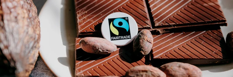 Tafel Schokolade mit Kakaobohnen und Fairtrade-Siegel.
