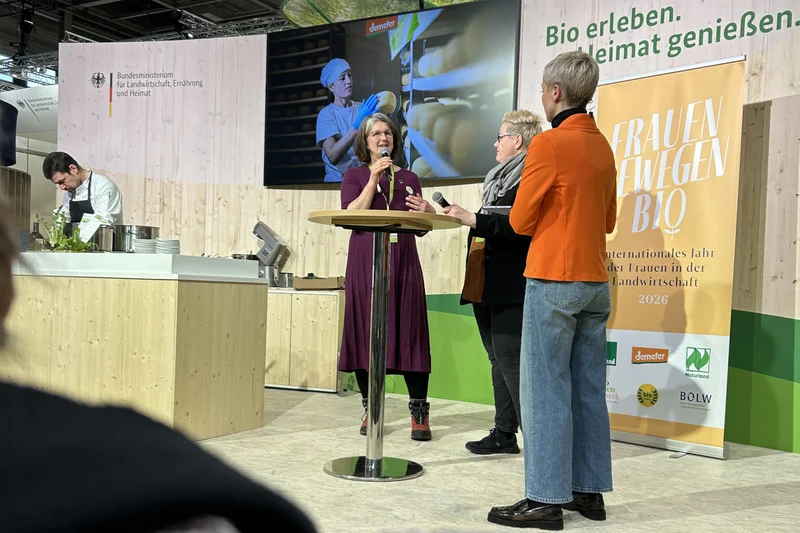Drei Frauen auf einer Bühne in während einer öffentlichen Diskussion. Klick führt zu Großansicht.