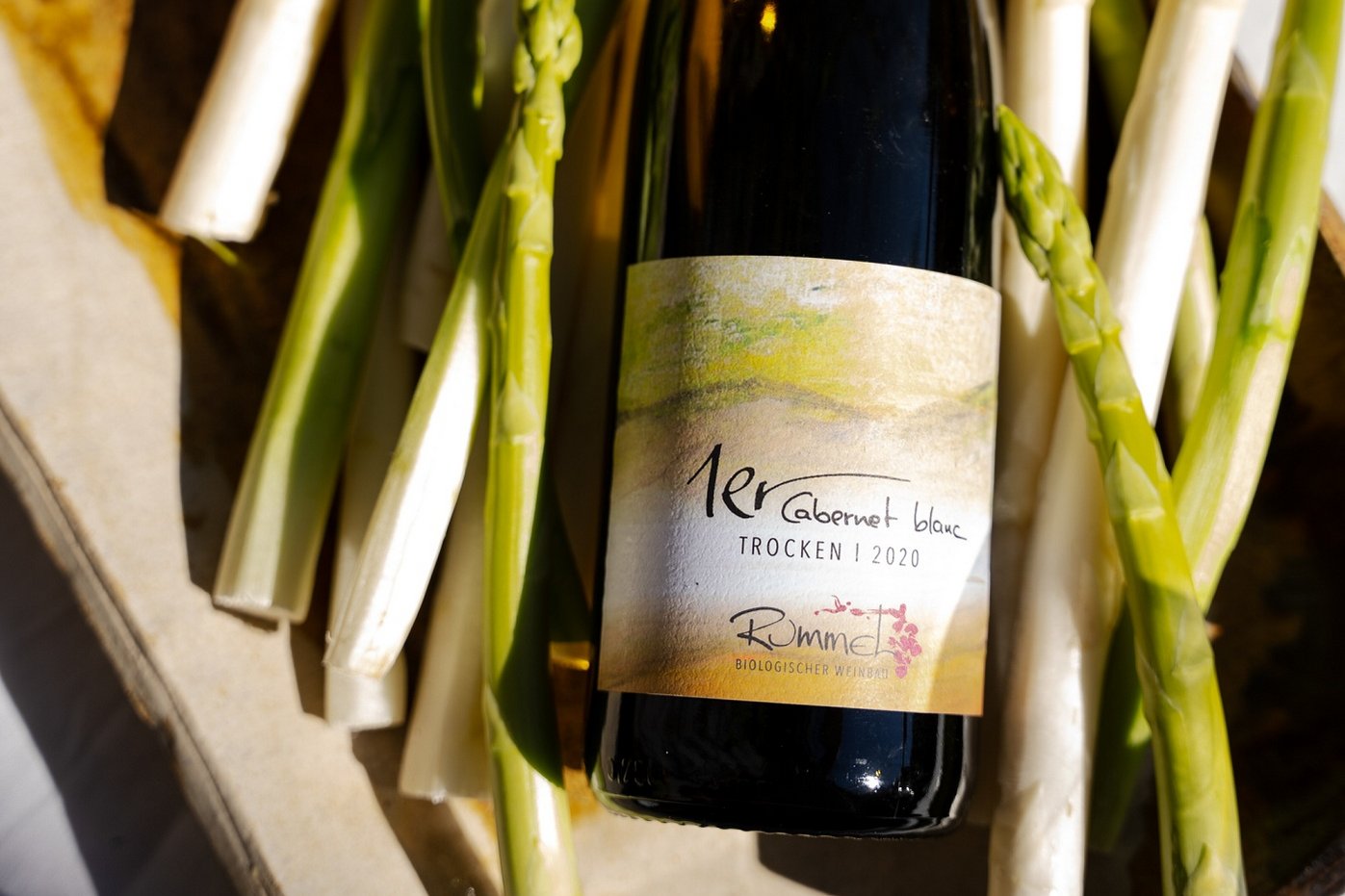 Weinflasche sowie grüner und weißer Spargel in einem Korb. Klick führt zu Großansicht.
