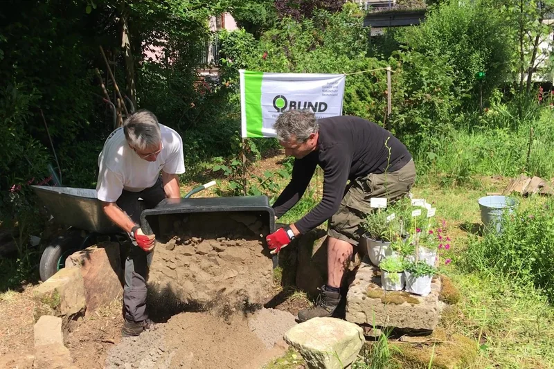 Männer bauen ein Sandarium. Klick führt zu Großansicht in neuem Fenster.