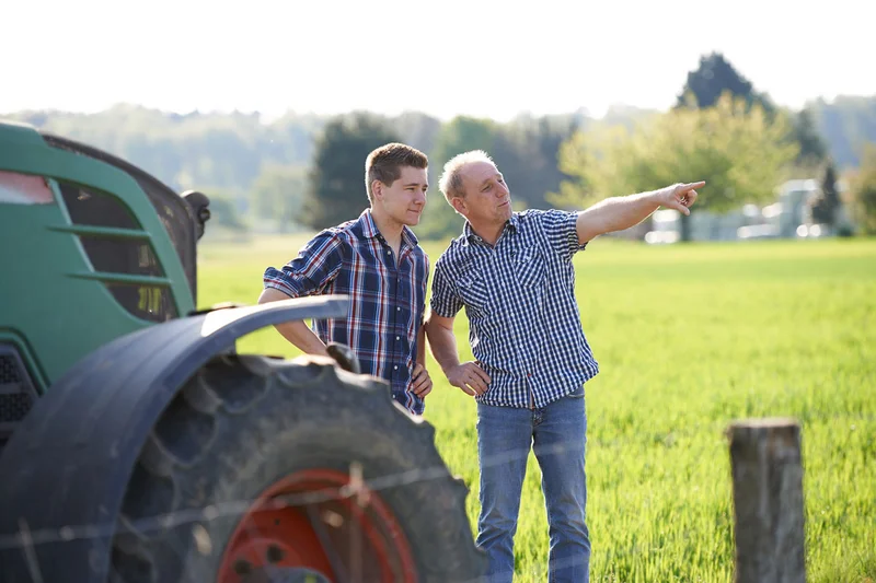 Zwei Männer neben einem Traktor